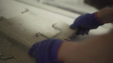 Beyaz erkeklerin fabrikanın beton karıştırma ünitesini açıp kapamalarının en üst görüntüsü. Mavi eldivenli tanınmayan adam fabrikadaki beton üretim sürecini kontrol ediyor..