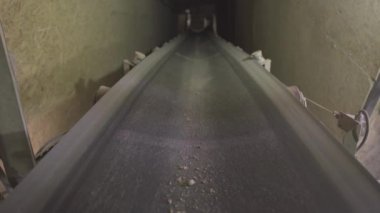 Çimento üretim tesisine toplu taşıma bandı yüklemenin ön görüntüsü. Beton fabrikasındaki endüstriyel ekipmanlar kapalı alanda üretiliyor..