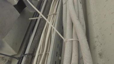 Kamera, üretim alanında kablo hatları olan kıvrımlı kollar boyunca hareket ediyor. Fabrikada ya da fabrikada elektrikli endüstriyel ekipman.