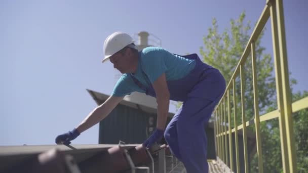 Überprüfung des automatisierten Verladeförderers auf Zementmischungen. Professionelle kaukasische Arbeiter in Uniform und Schutzhelm Inspektion Ausrüstung auf Beton Fertigungsfabrik oder Werk. — Stockvideo