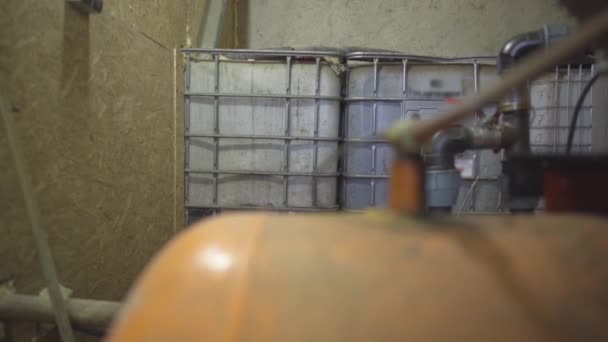 Grand tuyau métallique en acier à l'avant avec des réservoirs pour le stockage des réactifs chimiques à l'arrière-plan. Équipe industrielle et matériaux à l'usine ou à l'usine à l'intérieur. — Video