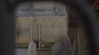 Endüstriyel yük traktörü sarı kum yığınını boşaltıp geri dönüyor. Beton üretim fabrikasına malzeme boşaltıyorum. Sürücü bakış açısı.
