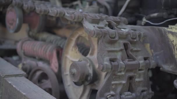 Primer plano de la pista del tractor oxidado. Parte de la maquinaria industrial. Componentes del vehículo rastreados al aire libre. — Vídeos de Stock