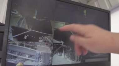 Beyaz bir erkek, fabrika güvenlik ofisindeki bilgisayar kameralarına bakıyor. Çimento üretim tesisinde üretim sürecinin kontrolü.