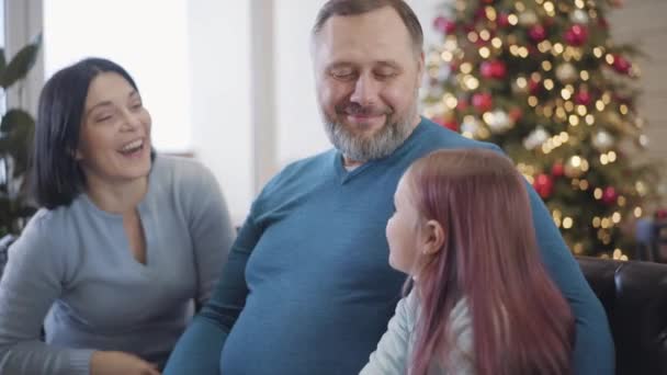 Souriant homme caucasien mi-adulte profitant week-ends de Noël avec sa femme et sa fille. Portrait de père et mari heureux donnant cinq à la famille. Concept de célébration du Nouvel An. — Video