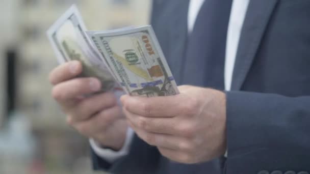 Mężczyzna kaukaskie ręce liczą pieniądze na ulicy miejskiej. Nierozpoznany bogacz trzymający paczkę dolarów. Koncepcja bogactwa i bogactwa. — Wideo stockowe