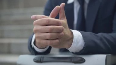 Dışarıda oturan stresli iş adamının yakın çekim elleri. Resmi takım elbiseli, tanınmayan bir avuç beyaz adamın sorunları var. Zorluklar ve sorunlar kavramı.