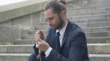 El ele tutuşup düşünen mutsuz iş adamının yan görünümü. İntihar etmeyi düşünen umutsuz, Kafkasyalı genç adam..