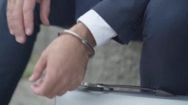 Ataşe çantasına kelepçelenmiş erkek eli yakın plan. Hükümet gizlilik belgelerine sahip tanınamaz bir gizli ajan ya da işten ayrılmaz bir iş adamının sembolü..