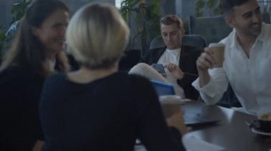 Kafeteryada neşeli iş arkadaşları konuşurken ve masada kahkahalar atarken beyaz adamın akıllı telefon kullanmasından sıkılmış. Yakışıklı, başarılı iş adamının portresi. İş arkadaşlarıyla sohbetle ilgilenmiyor..