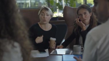 Kafede iş arkadaşlarıyla oturup konuşan heyecanlı beyaz kadın portresi. Başarılı iş kadını tatilde restoranda iş arkadaşlarıyla sohbet ediyor..