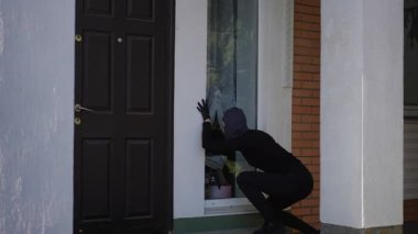 Gölgeli bir figür ön kapıdan bir eve girmeye çalışır ve şüpheli bir manzarayla sonuçlanır.