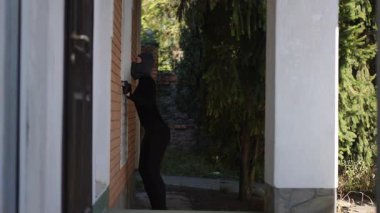 Maskeli bir şahıs, etrafı dikkatlice incelerken bir eve girmeye çalışırken görüldü.