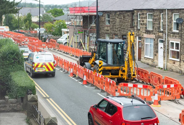 Roadworks kazıcı, engelleri ve trafik ile bir sokakta.