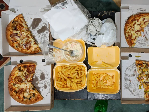 Overhead view of takeaway pizza meal partly eaten. — Stock Photo, Image