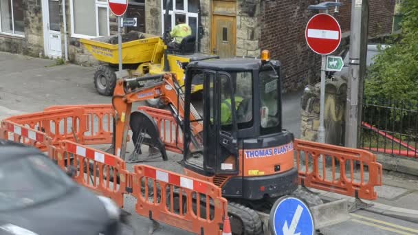 Pipe laying roadworks. Workmen, digger and dumper. Close up. — Stock Video