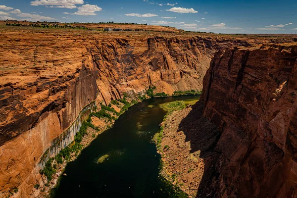 The Colorado River flows south through a thousand foot gorge from Glen Canyon Dam and Lake Powell near Page, Arizona on its way to Horseshoe Bend and the Grand Canyon.