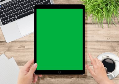 Dizüstü bilgisayar, bitkiler, kahve ofis ahşap masasında, insan eli holding tablet ile yeşil perde video üretimi için