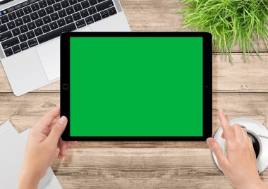 Dizüstü bilgisayar, bitkiler, kahve ofis ahşap masasında, insan eli holding tablet ile yeşil perde video üretimi için