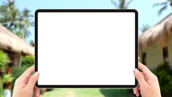 The human two hands holding tablet computer white screen mockup in the resort
