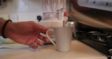 Bir fincan çay yaparken bir kupa için su ekleyerek bir adam çekim kapatın.