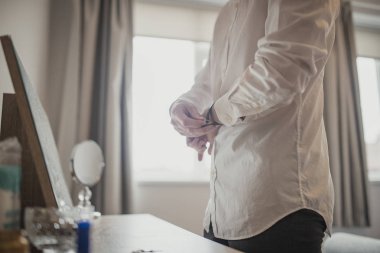 Bir saat koyarak bir şifoniyer masada duran bir unrecognisable kişi yan görünüm.