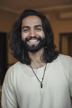 Yakın çekim, bir genç erkek yetişkin kameraya gülümseyen, önden görünüm headshot.