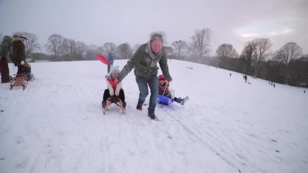 Mogen Man Drar Sina Döttrar Släde Snön — Stockvideo