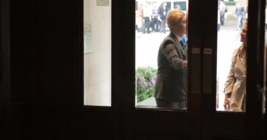 Bir iş toplantısı için bir otelin ön kapıdan yürüyerek iki iş adamları önden görünüm.