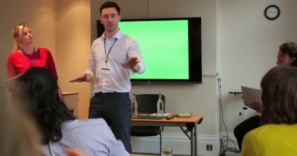 Par-dessus l'épaule des gens d'affaires qui regardent un présentateur lors d'une réunion. Poser et répondre aux questions .