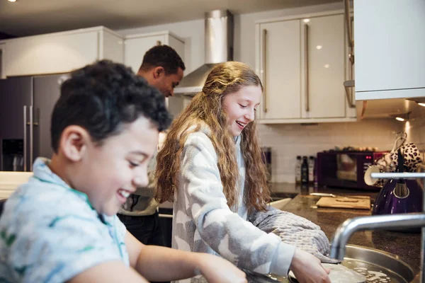 小女孩和她的弟弟在家里吃早饭后做菜 — 图库照片