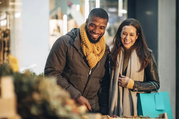 一对夫妇站在圣诞街市摊位的前视图决定他们应该买什么花圈 — 图库照片
