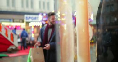 İzleme birlikte yürüyen genç bir çift bir kadeh. Noel alışveriş yaparken dükkan yürüyorlar.