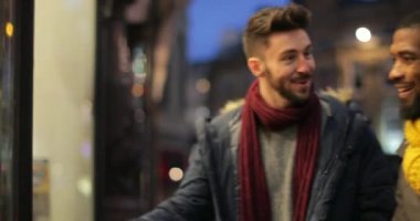 İzleme atış iki genç adamın bir vitrin için yürüyüş ve onların Noel alışveriş yaptıkları gibi vitrinler içinde arıyorum.
