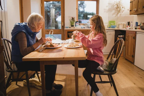 Side View Grandmother Her Granddaughter Sitting Dining Table Both Eating — Stock Photo, Image