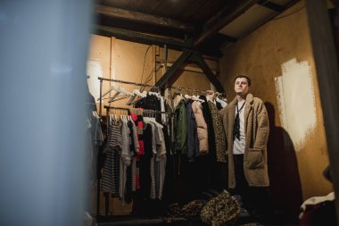 Moda Tasarımcısı Giyim raylar onun gardırop yanında poz. 