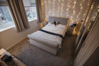 Empy student bedroom decorated with twinkle lights and teddy bears. clipart