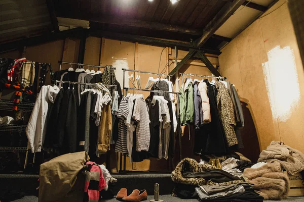 Pop-up dressing room with clothes on rails.