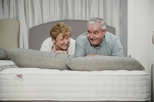 Para Starszych Leżą Łóżku Podczas Zakupów Sklepie Meblowym — Zdjęcie stockowe