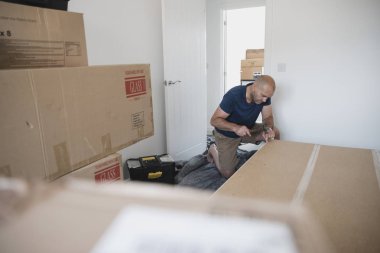 Olgun adam bir gardırop birlikte yeni bir ev bir yatak odasında koyuyor.