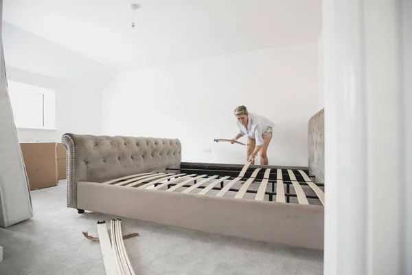 Rijpe Vrouw Bouwt Haar Bed Haar Nieuwe Huis Het Plaatsen — Stockfoto