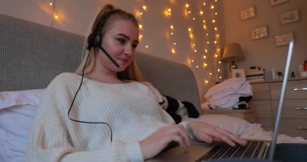 Junge Frau Sitzt Mit Einem Laptop Und Einem Headset Auf — Stockvideo