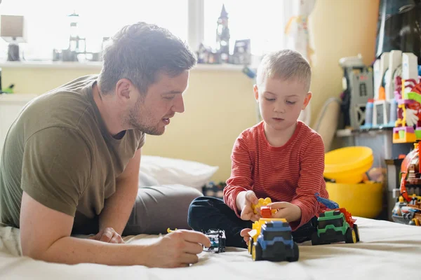 Menino Seu Pai Sentados Sua Cama Quarto Brincando Com Alguns — Fotografia de Stock