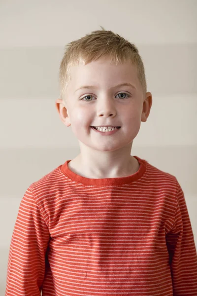 少年は肖像画のためのカメラを見ながら笑っている赤ストライプ シャツ — ストック写真