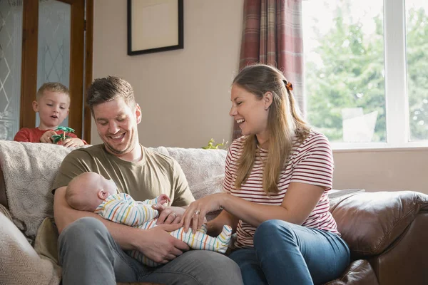 Man Vrouw Zitten Een Sofa Woonkamer Met Hun Pasgeboren Baby — Stockfoto