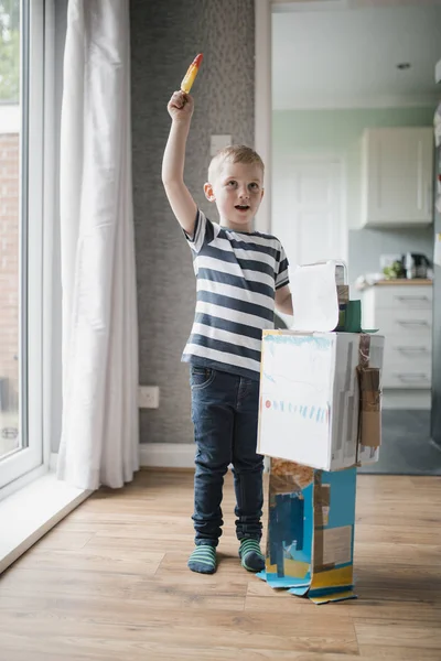 Kleine Jongen Binnenshuis Permanent Naast Een Zelfgemaakte Robot Die Hij — Stockfoto