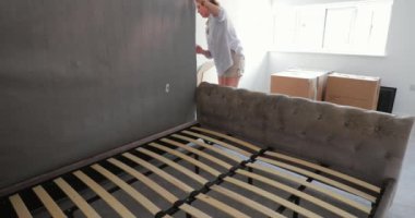 Olgun çift bir yatak yeni evlerinde yerleşik bir karyola üzerinde koyarak. 