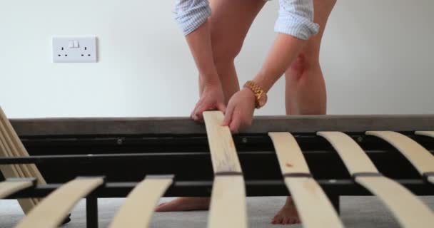 成熟的女人正在她的新家中建立一个床框架 她在加木板条 — 图库视频影像