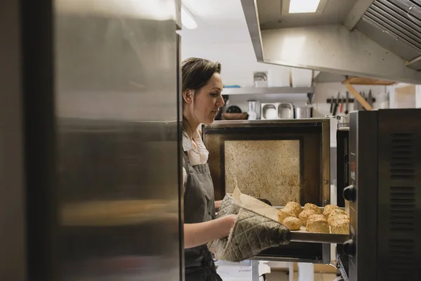 Orta Yetişkin Kadın Baker Pişmiş Çörekler Dışında Fırın Tepsisinin Çıkarılması — Stok fotoğraf
