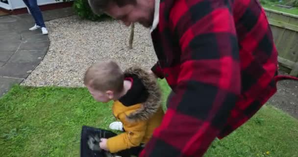 父と彼の少年の想像力を使って おもちゃの剣と盾を持つ草の庭で遊んで — ストック動画